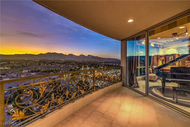 balcony at dusk featuring a mountain view