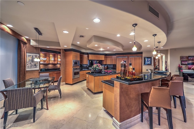 kitchen with decorative backsplash, appliances with stainless steel finishes, a center island, and decorative light fixtures