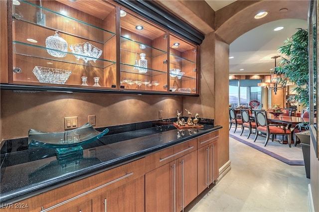 bar with pendant lighting and dark stone counters