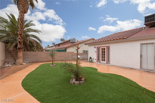 view of yard with central AC unit and a patio area