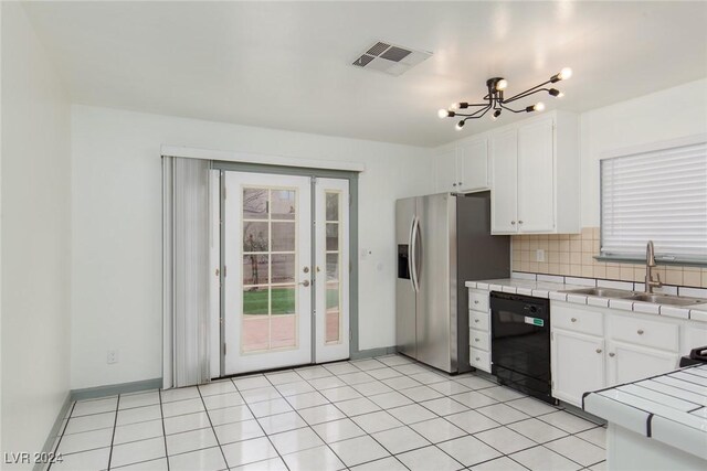 kitchen featuring sink, black dishwasher, white cabinets, decorative backsplash, and tile countertops