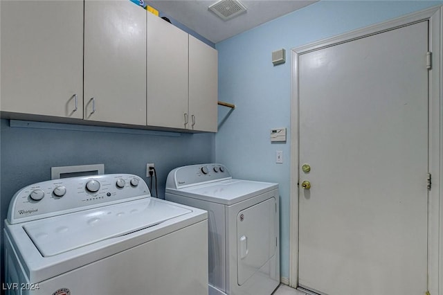 washroom featuring washing machine and dryer and cabinets