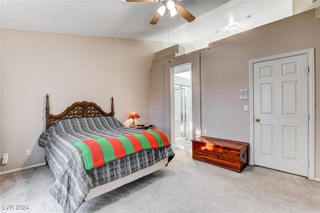 bedroom with lofted ceiling, ensuite bath, light colored carpet, and ceiling fan