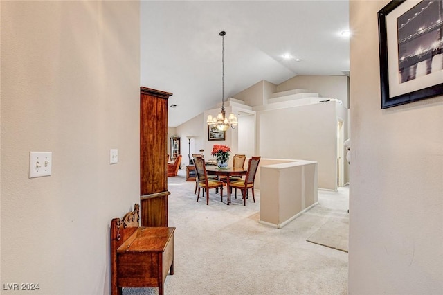 dining area with vaulted ceiling, a chandelier, and light carpet