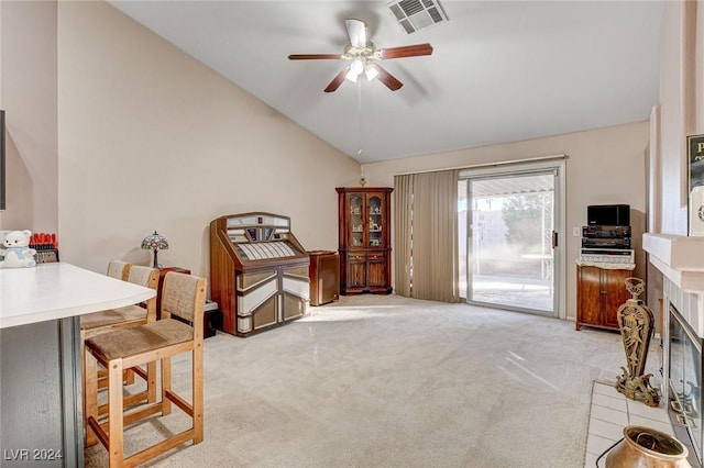 interior space with lofted ceiling, a fireplace, ceiling fan, and light carpet