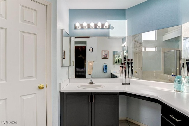 bathroom featuring a shower with shower door and vanity