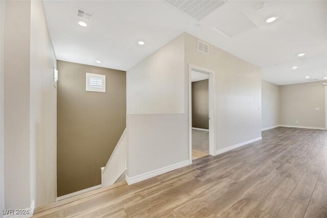 spare room featuring visible vents, recessed lighting, baseboards, and wood finished floors