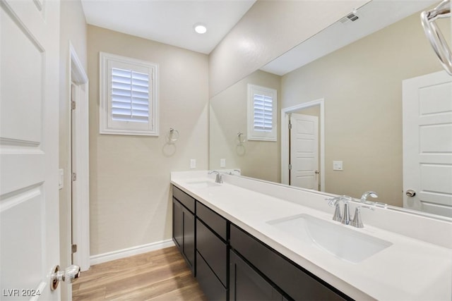 full bathroom featuring a sink, visible vents, baseboards, and wood finished floors