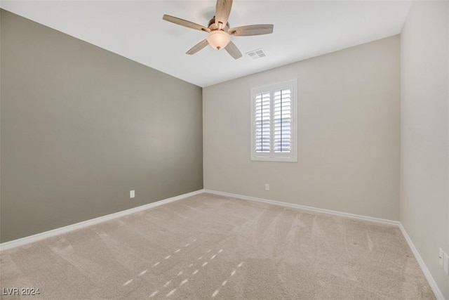 unfurnished room with visible vents, baseboards, carpet, and a ceiling fan