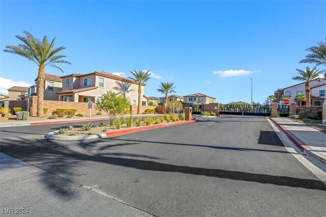 view of road featuring sidewalks, traffic signs, curbs, and a residential view