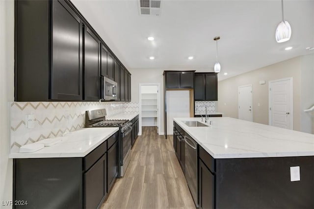 kitchen with stainless steel appliances, tasteful backsplash, hanging light fixtures, and sink