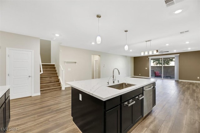 kitchen with visible vents, a sink, dishwasher, decorative light fixtures, and light wood-type flooring