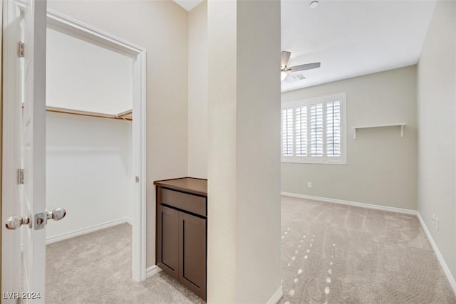 corridor featuring light carpet, visible vents, and baseboards