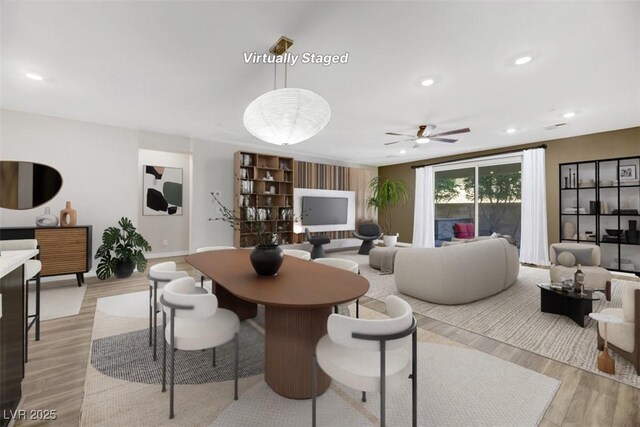 living room with recessed lighting, light wood-style flooring, and baseboards