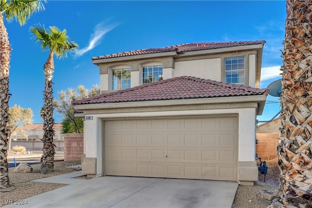 mediterranean / spanish-style house with a garage