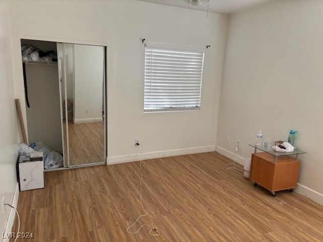 unfurnished bedroom featuring light hardwood / wood-style flooring and a closet