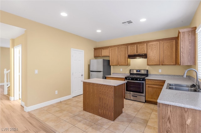 kitchen with light wood-type flooring, a center island, stainless steel appliances, and sink