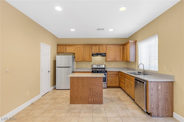 kitchen featuring appliances with stainless steel finishes, light tile patterned floors, a kitchen island, and sink