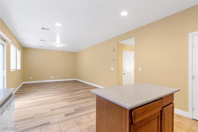 kitchen featuring dishwasher, a kitchen island, and light hardwood / wood-style flooring