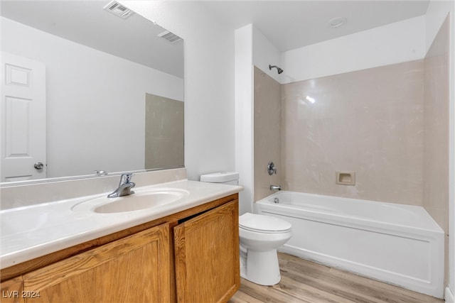 full bathroom with toilet, vanity, wood-type flooring, and washtub / shower combination