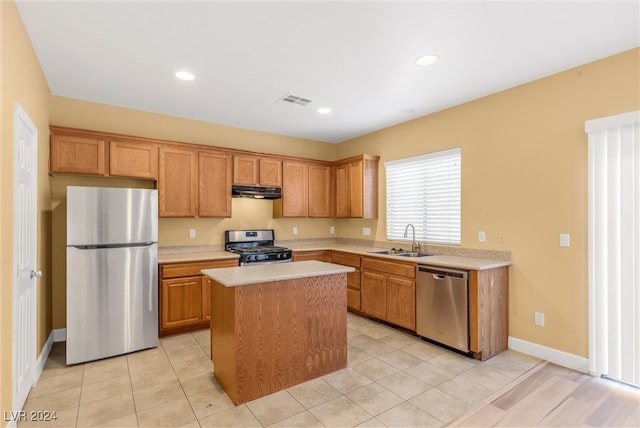 kitchen with a center island, light tile patterned flooring, stainless steel appliances, and sink