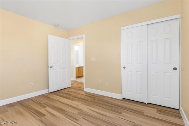 unfurnished bedroom featuring a closet and light wood-type flooring