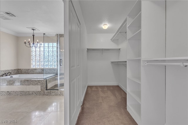 walk in closet featuring a notable chandelier and light colored carpet