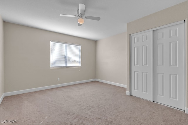 unfurnished bedroom with ceiling fan, a closet, and light colored carpet