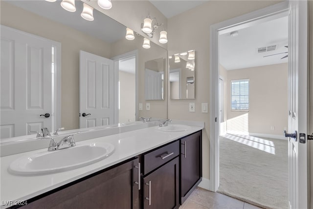 bathroom with a chandelier, vanity, and tile patterned floors