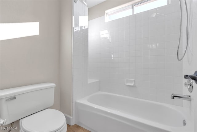 bathroom featuring tiled shower / bath and toilet