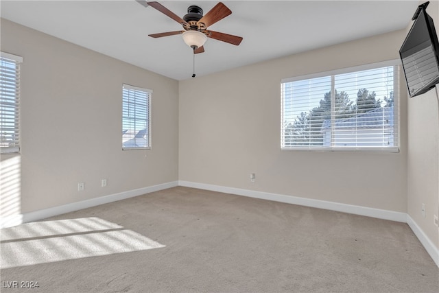 empty room with ceiling fan and light carpet