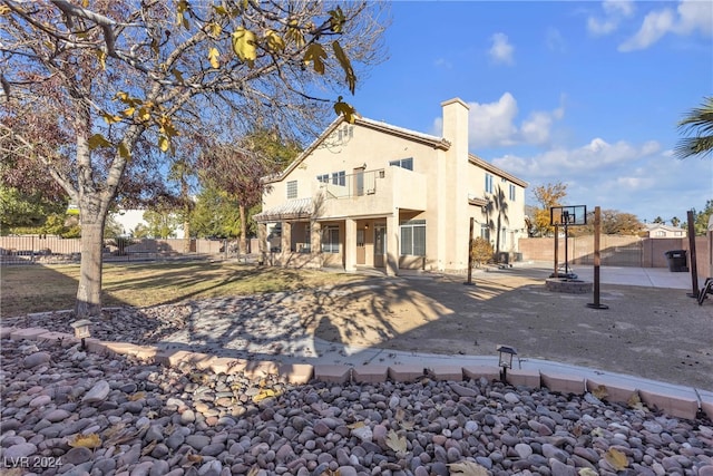 rear view of property featuring a balcony and a patio