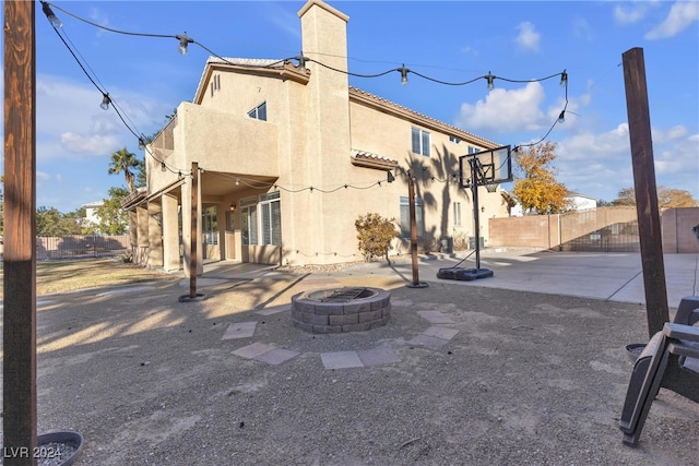 rear view of property with a fire pit and a patio area