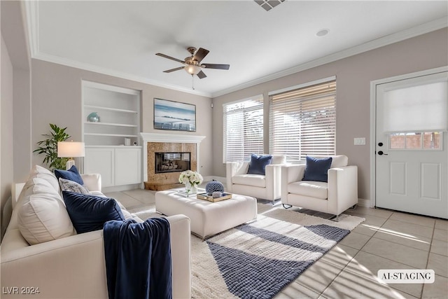 tiled living room with built in shelves, ceiling fan, and ornamental molding