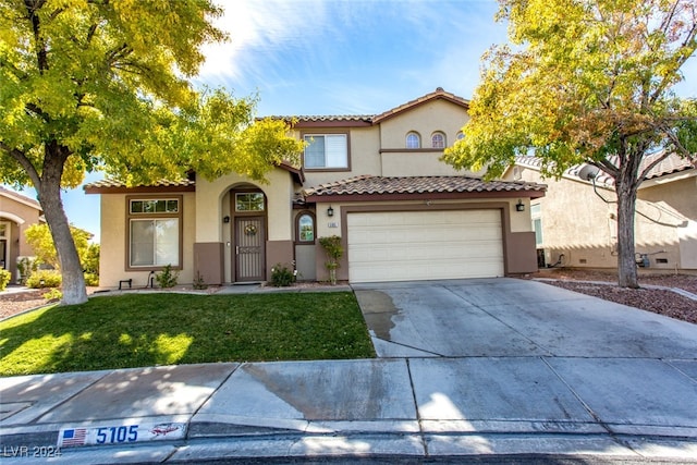 mediterranean / spanish-style home with a front yard and a garage