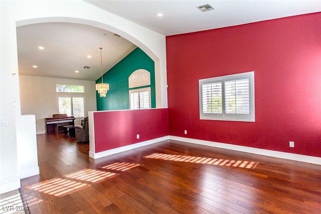 unfurnished room with dark hardwood / wood-style flooring, high vaulted ceiling, and a notable chandelier