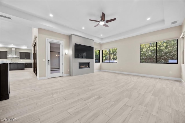 unfurnished living room with light hardwood / wood-style flooring and ceiling fan