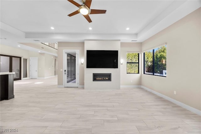 unfurnished living room featuring ceiling fan, french doors, and light hardwood / wood-style flooring