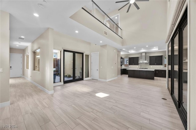 unfurnished living room featuring french doors, light hardwood / wood-style flooring, and ceiling fan