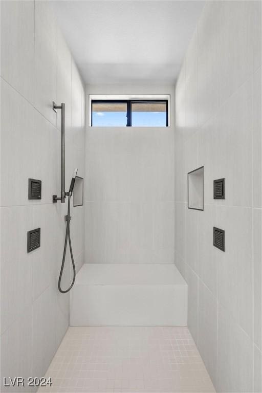 bathroom with tile patterned flooring and a tile shower