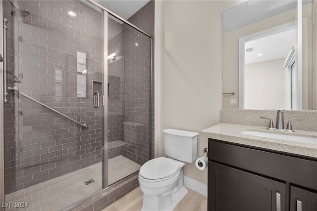 bathroom featuring walk in shower, toilet, vanity, and hardwood / wood-style flooring