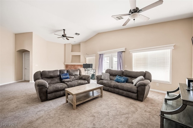 living room with ceiling fan, light colored carpet, and vaulted ceiling