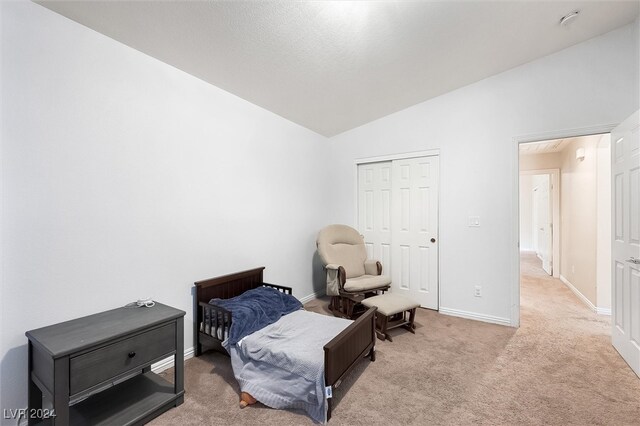 carpeted bedroom featuring a closet and lofted ceiling