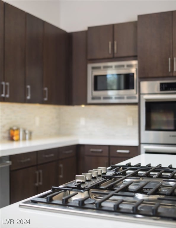 kitchen featuring decorative backsplash, dark brown cabinetry, and stainless steel appliances