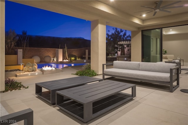 patio at night with an outdoor living space and ceiling fan