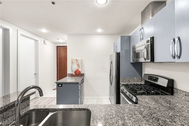 kitchen featuring dark stone countertops, sink, gray cabinetry, and appliances with stainless steel finishes