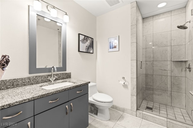 bathroom with tile patterned floors, vanity, toilet, and a shower with door