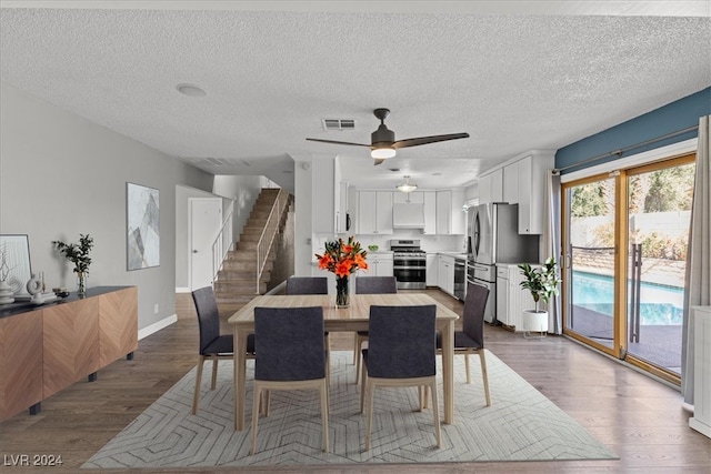 dining area with hardwood / wood-style floors, ceiling fan, and a textured ceiling