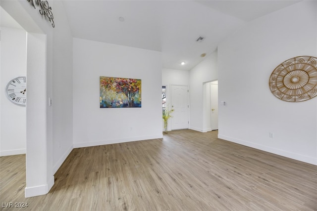 unfurnished room with light hardwood / wood-style flooring and vaulted ceiling