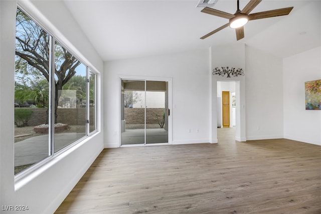 empty room featuring hardwood / wood-style flooring, vaulted ceiling, and ceiling fan